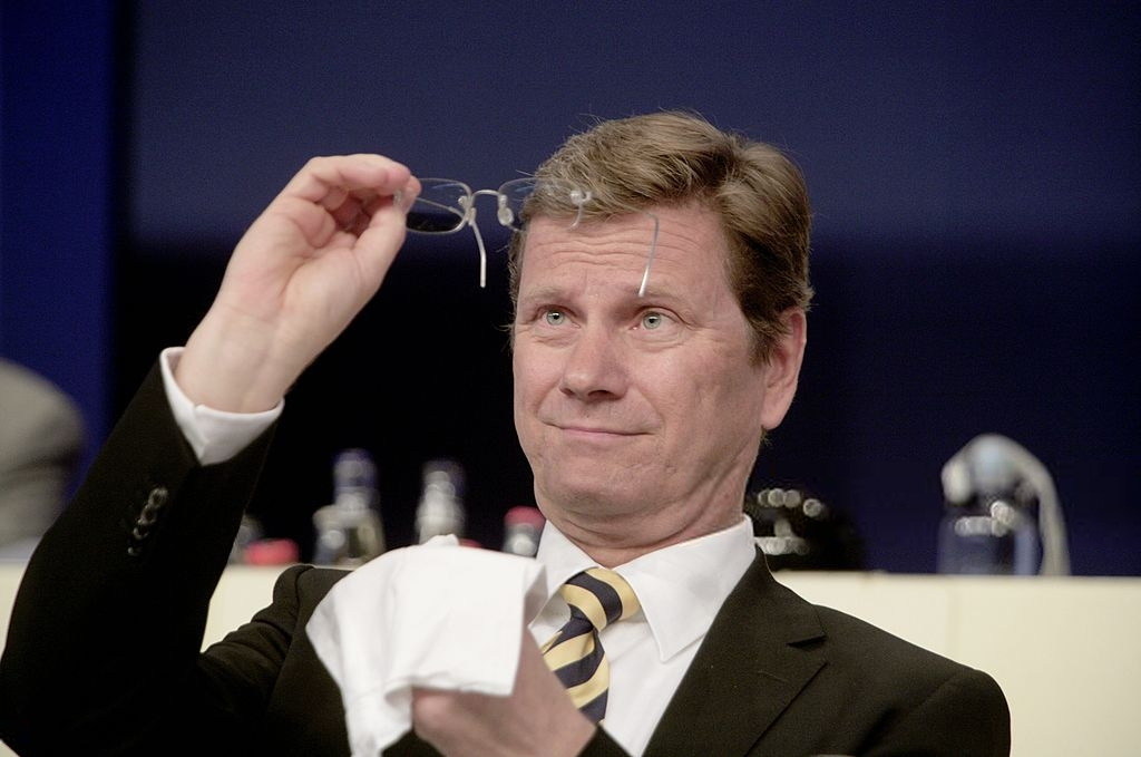 a man cleans his eyeglasses