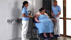 fat woman being helped in toileting by caregivers