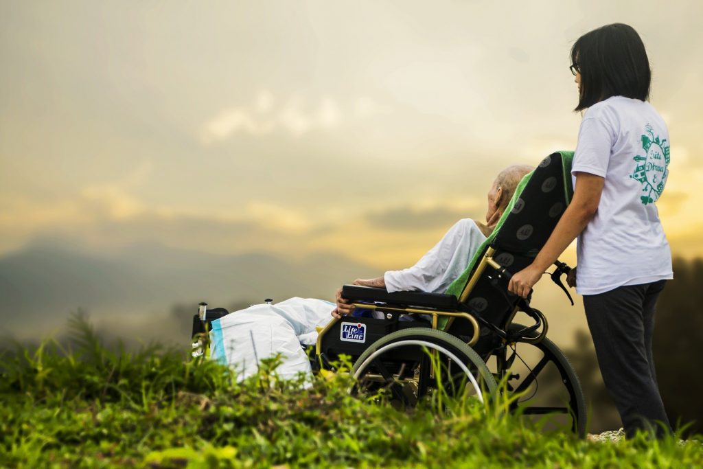 a hospice patient wheeled by caregiver