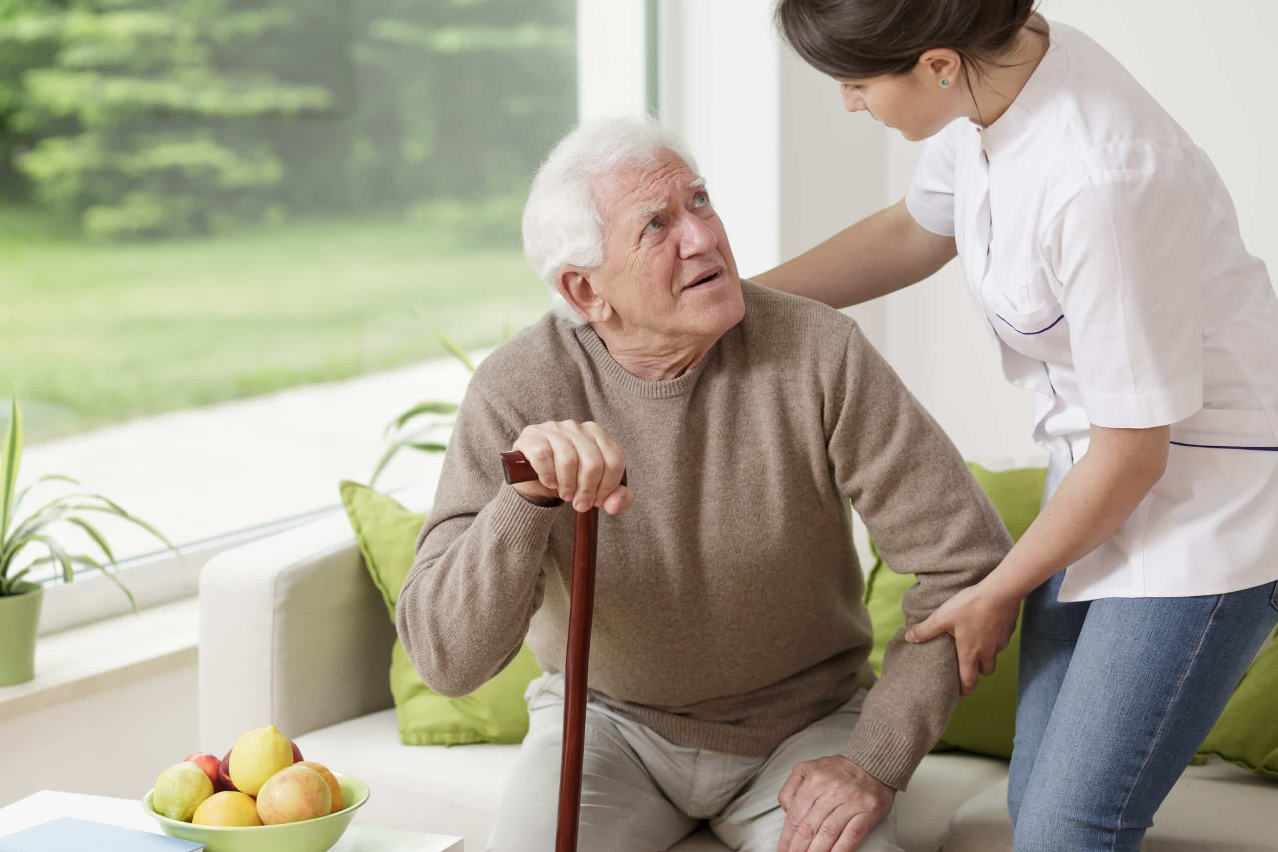 Young,Woman,Helping,Old,Man, with parkinson To,Stand,Up